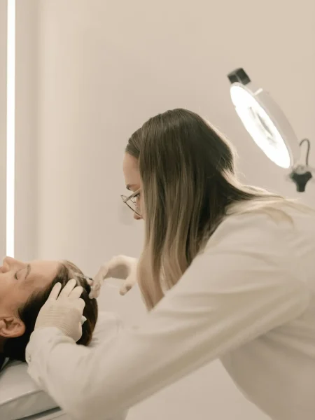 Dermatologist performing a treatment in a clinic setting with specialized equipment.
